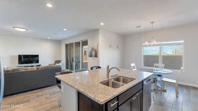 kitchen featuring a center island with sink, light hardwood / wood-style floors, sink, and dishwasher