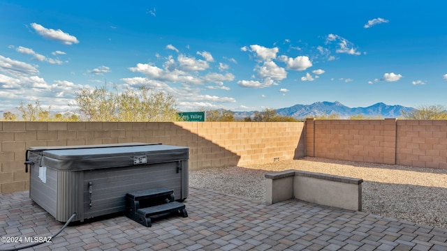 view of patio featuring a hot tub and a mountain view