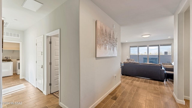 hall featuring separate washer and dryer and light hardwood / wood-style flooring