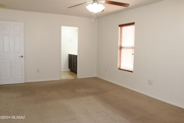 carpeted spare room featuring ceiling fan