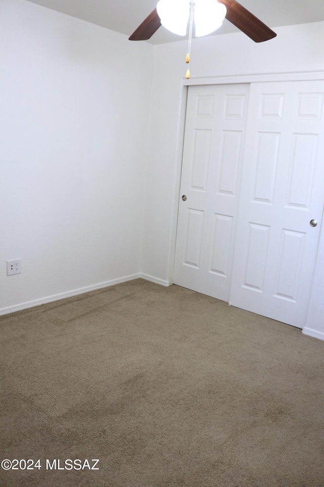 unfurnished bedroom featuring carpet flooring, a closet, and ceiling fan