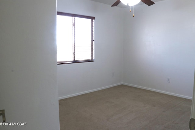 carpeted spare room with ceiling fan