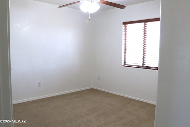 carpeted spare room featuring ceiling fan