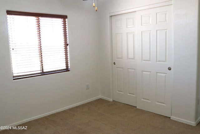 unfurnished bedroom with a closet and carpet floors