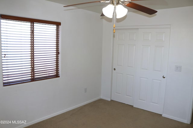 unfurnished bedroom with carpet flooring, a closet, and ceiling fan