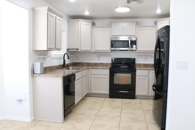 kitchen featuring black appliances, light tile patterned flooring, white cabinetry, and sink