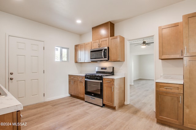 kitchen featuring light hardwood / wood-style floors, ceiling fan, and stainless steel appliances