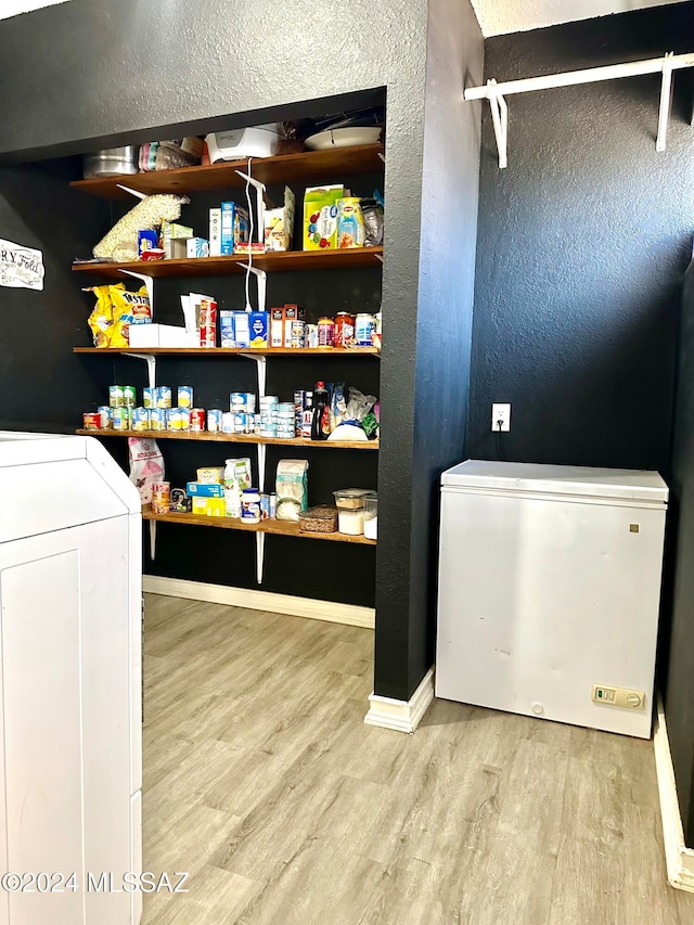 laundry room with light hardwood / wood-style floors and washer and dryer