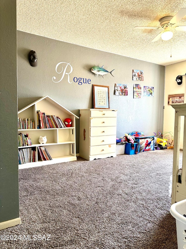 playroom featuring carpet floors, a textured ceiling, and ceiling fan