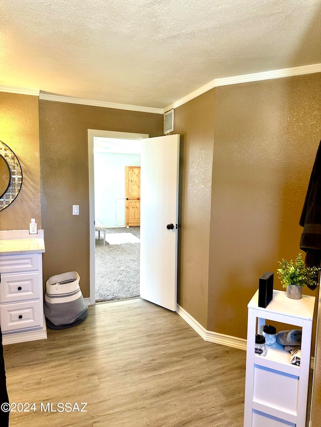 bathroom with vanity, ornamental molding, a textured ceiling, and hardwood / wood-style floors