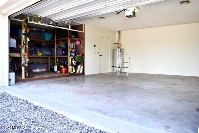 garage with gas water heater and a garage door opener