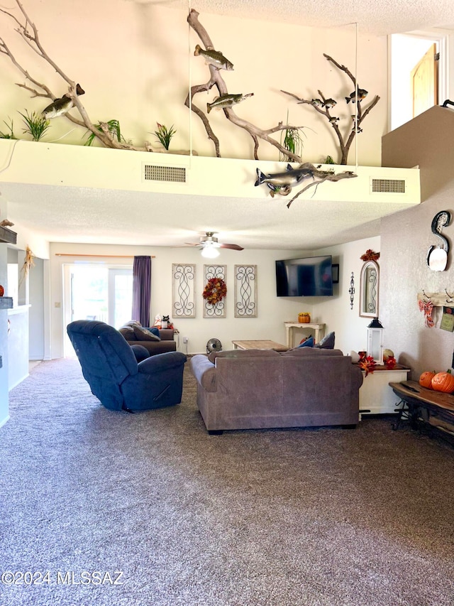 carpeted living room featuring ceiling fan and a textured ceiling