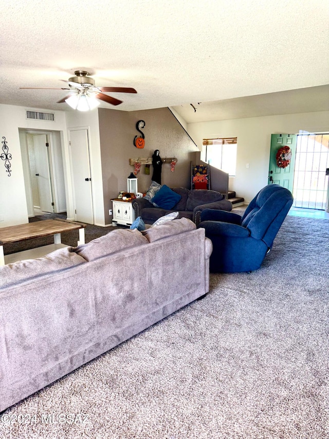 living room featuring ceiling fan, a textured ceiling, and carpet flooring