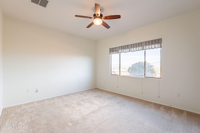 spare room featuring light carpet and ceiling fan