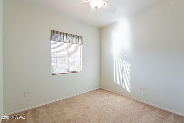 empty room with ceiling fan and light carpet