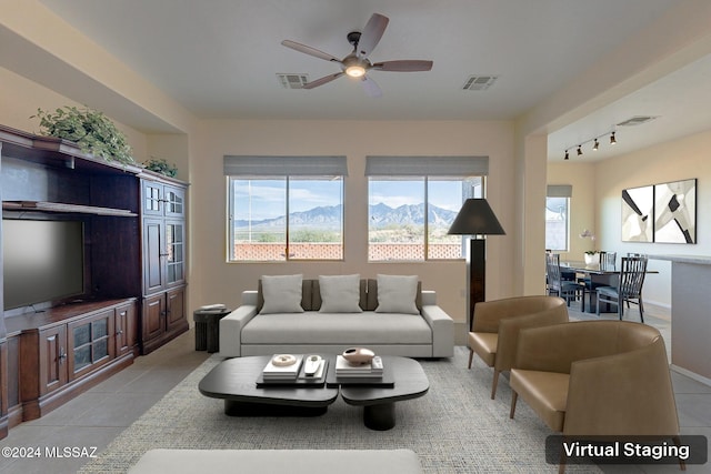 living room with a mountain view, ceiling fan, light tile patterned floors, and track lighting