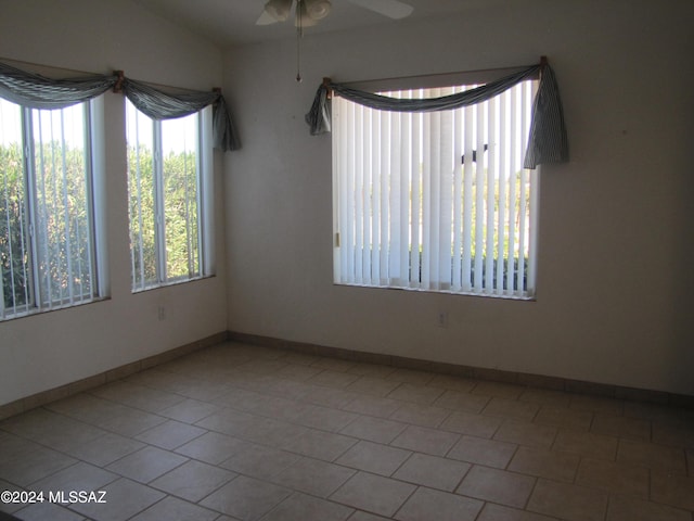 spare room featuring lofted ceiling, ceiling fan, and light tile patterned floors