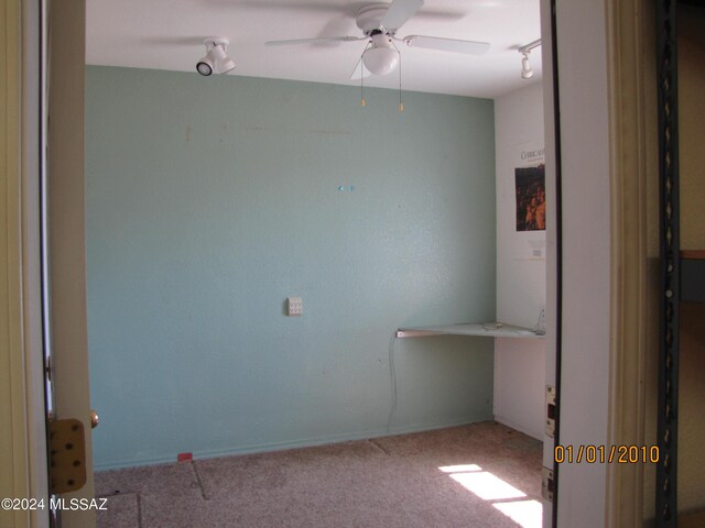 carpeted spare room with ceiling fan