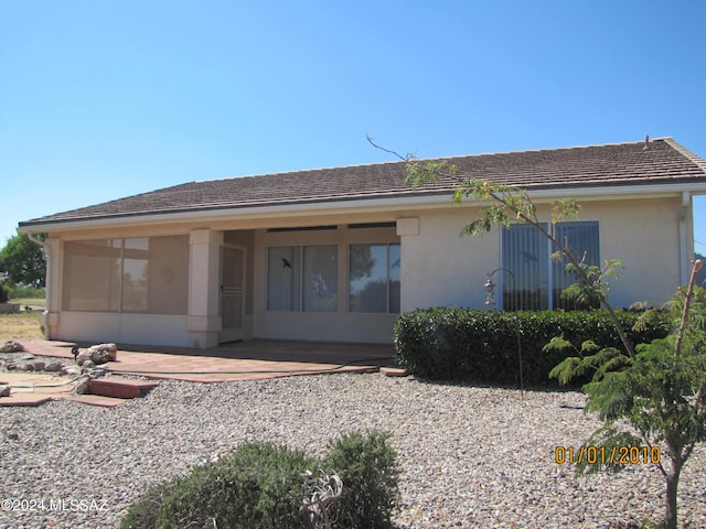 rear view of property with a sunroom and a patio area