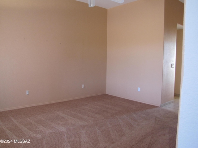 carpeted spare room featuring ceiling fan