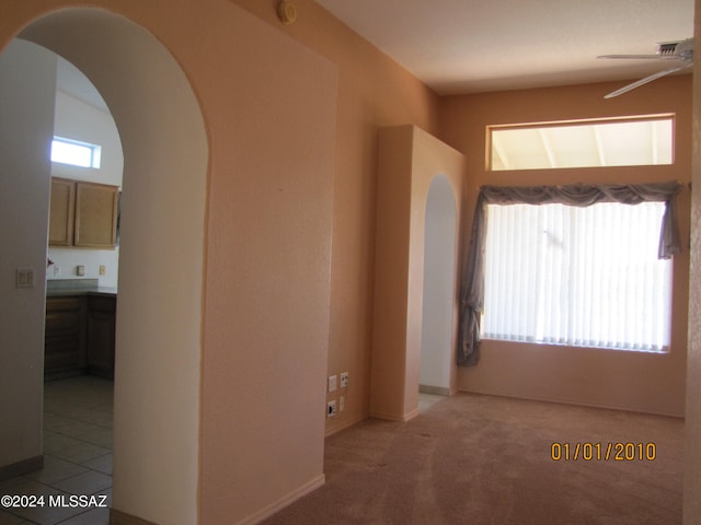 spare room with ceiling fan and light carpet