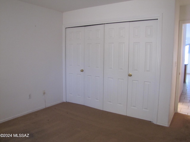 unfurnished bedroom featuring dark hardwood / wood-style flooring and a closet