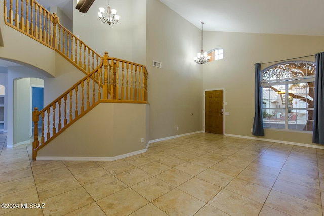 foyer with high vaulted ceiling, light tile patterned floors, and a chandelier