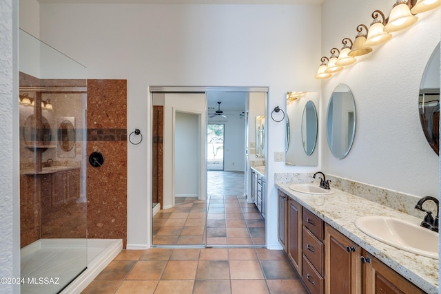 bathroom featuring tile patterned floors, ceiling fan, vanity, and tiled shower