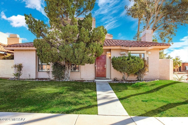 mediterranean / spanish house featuring a front lawn