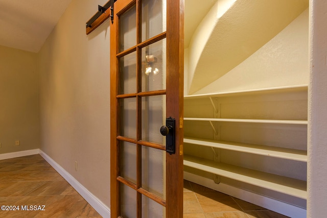 interior space with tile patterned floors and a barn door