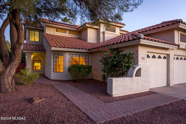 mediterranean / spanish-style home with a garage