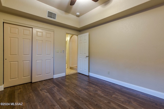 unfurnished bedroom with ceiling fan, a closet, and dark hardwood / wood-style flooring