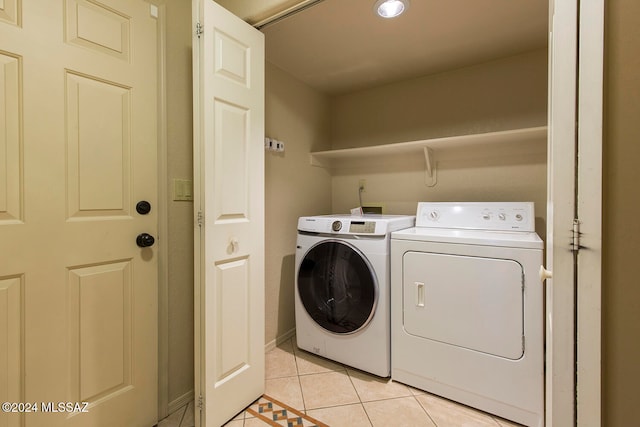 laundry room with washing machine and dryer and light tile patterned floors