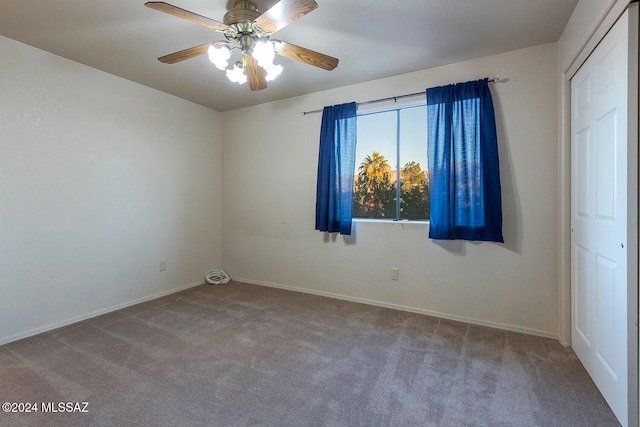 carpeted spare room with ceiling fan