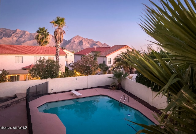 pool at dusk featuring a mountain view