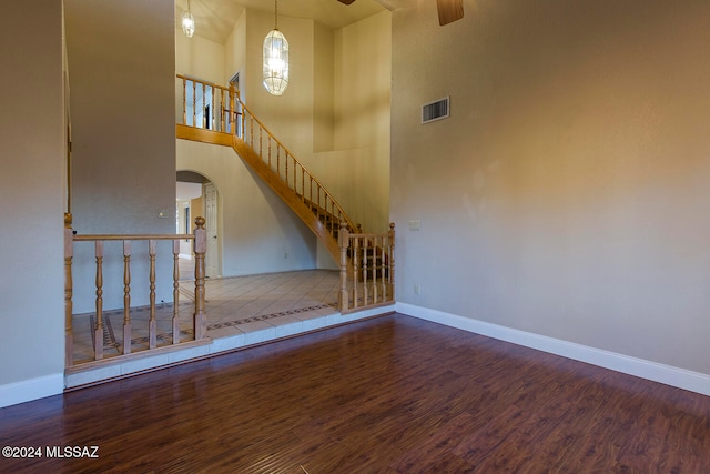 interior space featuring ceiling fan, a towering ceiling, and hardwood / wood-style floors