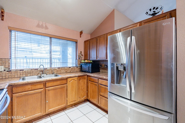 kitchen with stainless steel appliances, backsplash, vaulted ceiling, and sink