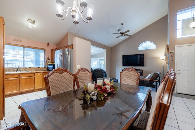 tiled dining room with ceiling fan with notable chandelier, sink, and high vaulted ceiling