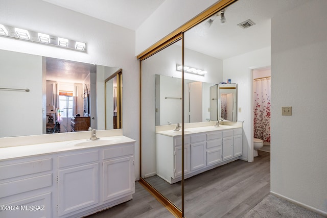 bathroom with hardwood / wood-style flooring, vanity, and toilet