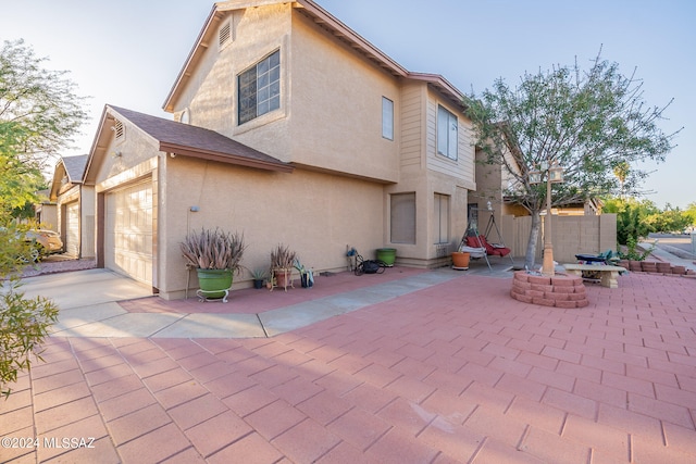 back of house featuring a garage and a patio area