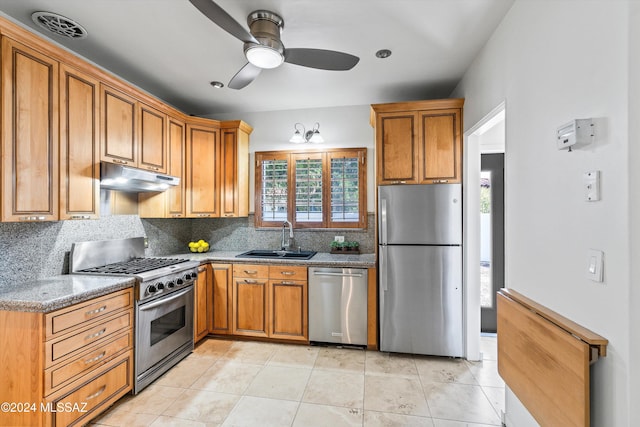 kitchen with appliances with stainless steel finishes, stone countertops, tasteful backsplash, sink, and ceiling fan