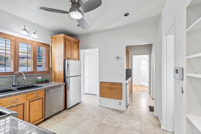 kitchen featuring appliances with stainless steel finishes, sink, decorative backsplash, and light tile patterned floors