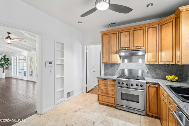 kitchen featuring light tile patterned flooring, appliances with stainless steel finishes, built in features, sink, and backsplash