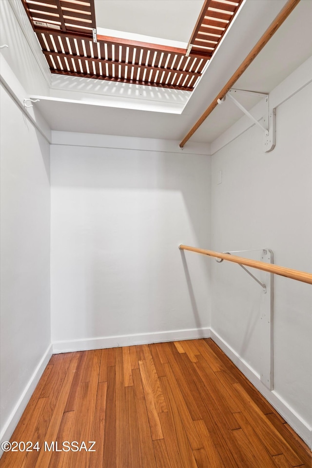 walk in closet with hardwood / wood-style flooring