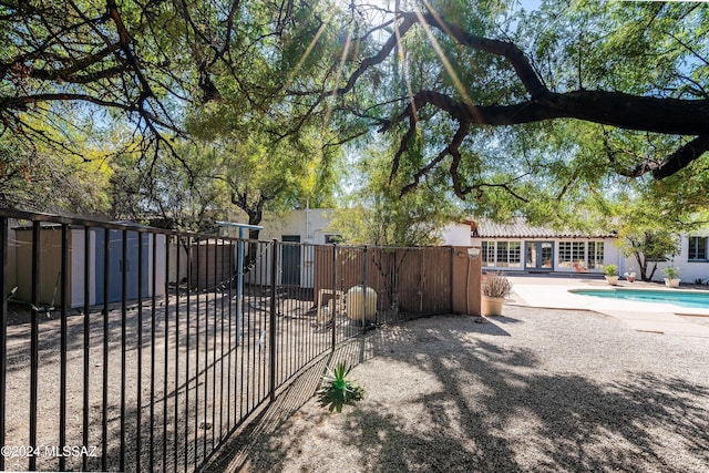 view of gate with a fenced in pool and a patio area