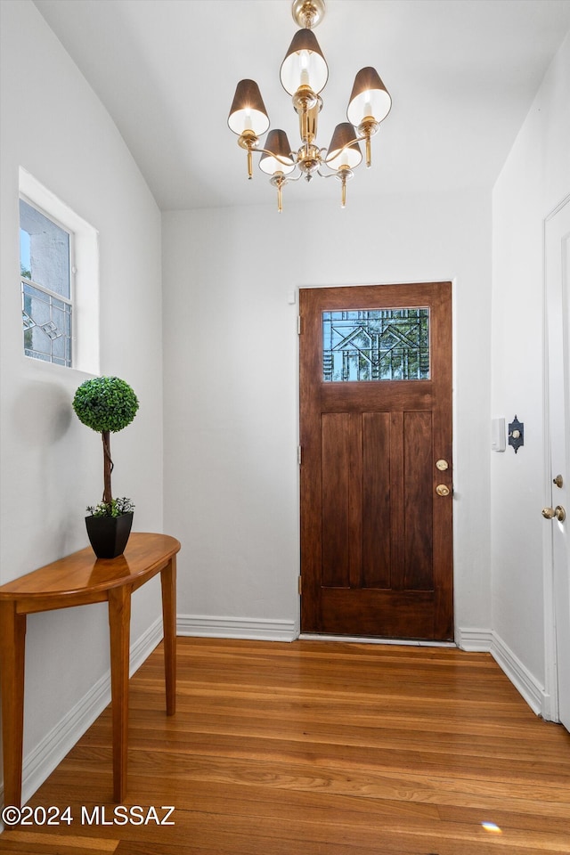 entrance foyer featuring an inviting chandelier and hardwood / wood-style flooring