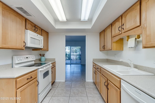 kitchen with light countertops, white appliances, visible vents, and a sink