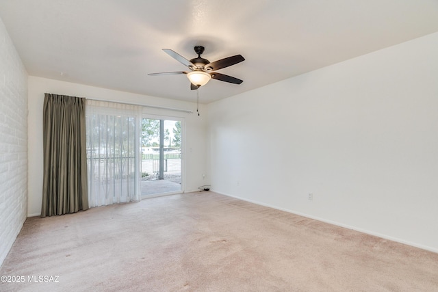 spare room featuring light carpet and a ceiling fan