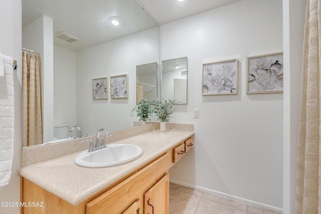 full bathroom with toilet, vanity, baseboards, visible vents, and tile patterned floors