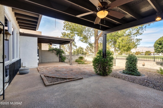 view of patio with ceiling fan, a mountain view, and a fenced backyard